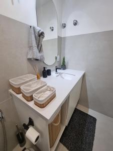 uma casa de banho com um lavatório branco e um espelho. em 1031 - London Class Suítes em São Paulo