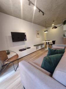 uma sala de estar com um sofá e uma televisão de ecrã plano em 1031 - London Class Suítes em São Paulo