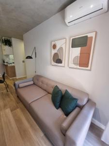 una sala de estar con un sofá marrón en una habitación en 1031 - London Class Suítes, en São Paulo
