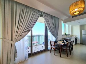 een eetkamer met een tafel en een groot raam bij Luxury Marina Apartment 1 in Dubai