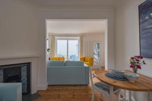 a living room with a blue couch and a table at Wave Cottage by Bloom Stays in Sandgate