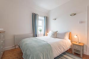 a white bedroom with a bed and a window at Wave Cottage by Bloom Stays in Sandgate