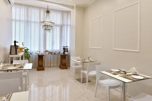 a white dining room with white tables and chairs at Residenza Borbonica in Naples