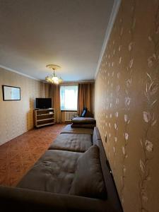 a living room with a couch and a tv at Nice and Cosy two bedrooms parking balcony apartment in Rīga