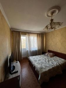 um quarto com uma cama e uma televisão em Nice and Cosy two bedrooms parking balcony apartment em Riga