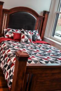 1 cama con edredón y almohadas en blanco y negro en A Luxurious 5 star Location 2 QUEEN Bed’s TROY, en Troy