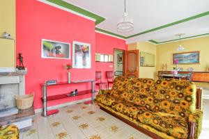 a living room with a couch and a red wall at Villa Marchionni in Cese