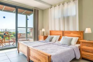 a bedroom with a large bed and a balcony at Giorgio Mounda Beach Kefalonia in Ratzaklíon
