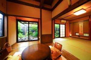 Pokój z drewnianym stołem i oknami w obiekcie Yurari Rokumyo w mieście Yufu