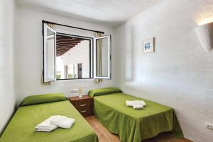 ビニベカにあるBini Blancaの窓付きの客室で、緑色のベッド2台が備わります。