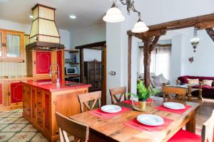 a kitchen and dining room with a wooden table at Ático Imperial GARAJE GRATIS Céntrico Terraza Aire Acond Solarium 2 baños wifi a 1minuto de la Plaza Cabildo in Sanlúcar de Barrameda