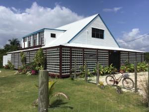 une maison blanche avec un vélo devant elle dans l'établissement The BNB on Triggerfish Close to the airport, à Ladyville