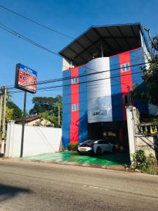 um edifício com um carro estacionado em frente em Alina Budget Hotel em Kaduwela