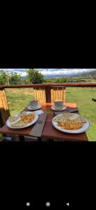 einem Holztisch mit zwei Teller Essen drauf in der Unterkunft Glamping Barichara in Barichara