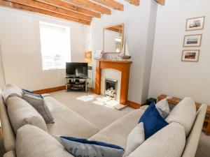 a living room with a couch and a fireplace at Awel Y Mor in Pwllheli