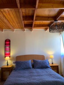 1 dormitorio con 1 cama con sábanas azules y lámpara roja en Sami Atacama, en San Pedro de Atacama