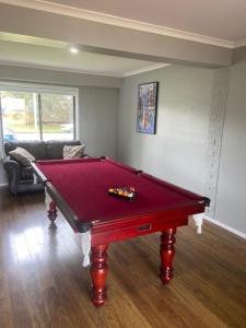 a red pool table in a living room at Lakefront Holiday Home in Berkeley Vale