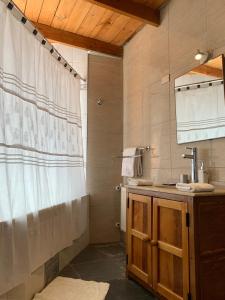 y baño con cortina de ducha y lavamanos. en Sami Atacama en San Pedro de Atacama