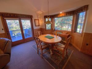 een eetkamer met een houten tafel en stoelen bij O4 - NEW 1 minute walk from beginner ski trail in the heart of Bretton Woods in Carroll