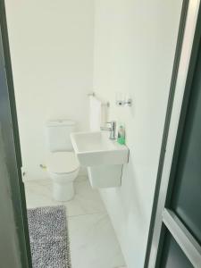 une salle de bains blanche avec toilettes et lavabo dans l'établissement Legacy Court, à Ashalebotwe 19 autres photos