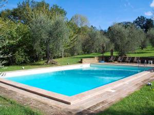 een groot zwembad in een tuin met bomen bij Belvilla by OYO Podere Torre in Palaia