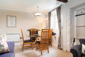 a living room with a dining room table and chairs at Rhubarb Cottage in Chapel Stile