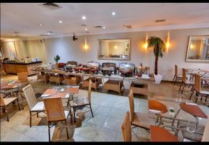 ein Restaurant mit Tischen und Stühlen und eine Bar in der Unterkunft Hotel International Plaza Jardins in São Paulo