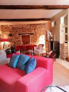 a pink couch with blue pillows in a living room at La Maison d’Helene & Antoine à Bonnieux XII siècle in Bonnieux