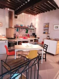 a kitchen with a table and chairs in it at La Maison d’Helene & Antoine à Bonnieux XII siècle in Bonnieux