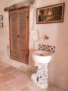 a bathroom with a white toilet and a window at La Maison d’Helene & Antoine à Bonnieux XII siècle in Bonnieux