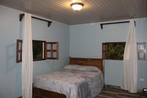 a bedroom with a bed and two windows at Cabaña Kundalini in Antón