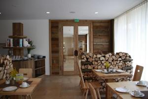 a room with wooden tables and a pile of logs at Beim Rinderwirt in Sigmaringendorf