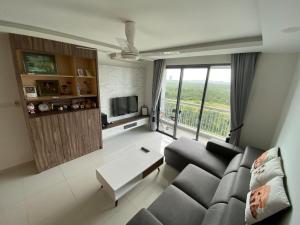 a living room with a couch and a large window at Johor Malaysia Teega Suites@ Puteri Harbour Condo 4607 Persiaran Lasamana , Teega Suites in Nusajaya