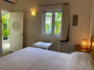 1 dormitorio con cama blanca y ventana en Hotel La Piazzetta en Mérida