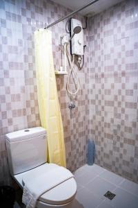 y baño con aseo y ducha. en Chambre Hotel Mactan en Isla de Mactán