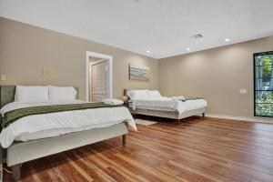 ein großes Schlafzimmer mit 2 Betten und einem Fenster in der Unterkunft Modern 6br Villa Resort Style Pool On Golf Course in Pompano Beach