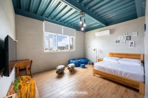 1 dormitorio con 1 cama y techo azul en Liuqiu Backpackers Hostel en Xiaoliuqiu