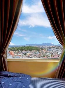 ダラットにあるSori Houseのベッドルーム1室(市街の景色を望む窓付)