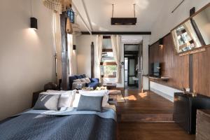 a bedroom with a bed and a living room at Humz Canal Stay in Nonthaburi