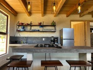 uma cozinha com um balcão com cadeiras e um frigorífico em Loft Lobo Tapalpa em Tapalpa