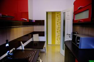 a kitchen with red and yellow cabinets and a microwave at Vila HD in Hunedoara