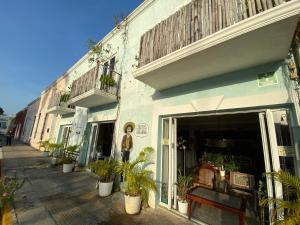 une femme debout devant un bâtiment avec des plantes dans l'établissement Hotel La Piazzetta, à Mérida