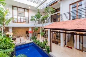 an indoor courtyard with a swimming pool and a house at Villa Aviya in Jimbaran