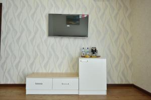 ein weißer Schrank mit einem TV an der Wand in der Unterkunft SATO HOTEL TASHKENT in Taschkent