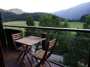 a wooden table and chairs on a balcony with a view at Triglav Park House in Bled