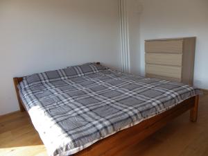 a bed with a plaid blanket and a dresser in a room at Triglav Park House in Bled +18 photos