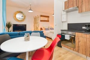 a kitchen and living room with a white table and red chairs at Bien-être et bonheur au pied des Thermes in Allevard