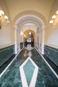 um corredor vazio de um edifício com piso de mármore em Residence Victoria em Trieste
