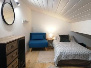 een slaapkamer met een bed en een blauwe stoel bij Domaine de Cayre in Mervilla