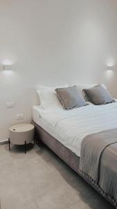 uma cama branca com duas almofadas e uma mesa em RAG Marine Winner - Lovely Sea Front luxury em Herzliya B